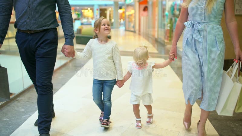 Glückliche vierköpfige Familie, die das Einkaufen tut Familie im Mall Kinder am Mall mit Eltern Familieneinkaufen im Kaufhaus Zwe