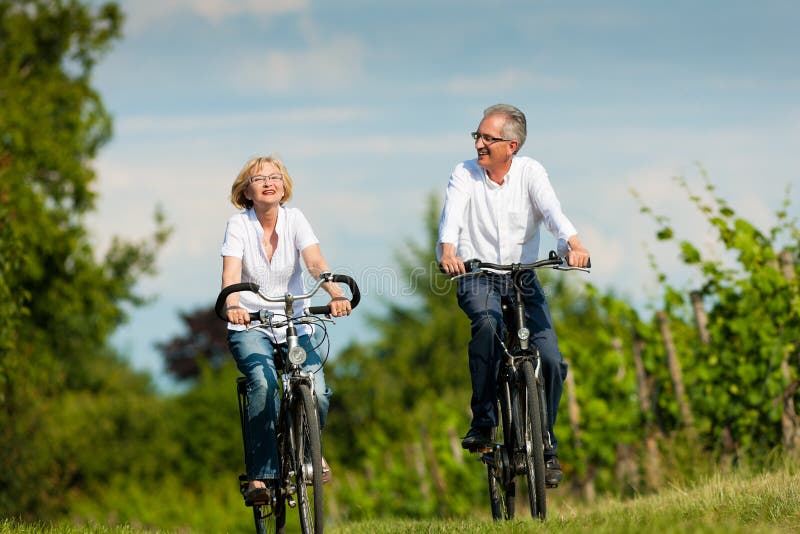 Glückliche ältere Paare, die draußen am Sommer einen Kreislauf durchmachen