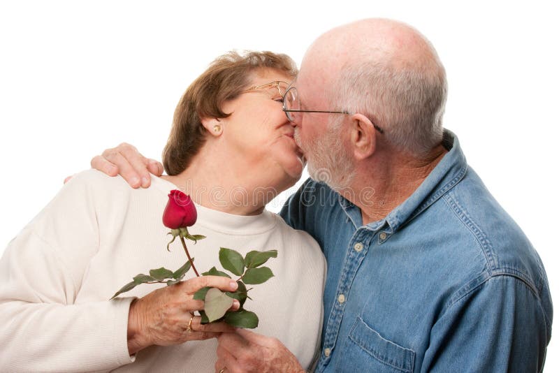 Glückliche ältere Paare, die mit roter Rose küssen lizenzfreies stockfoto Glückliche ältere Paare, die mit roter Rose küssen lizenzfreies stockfoto