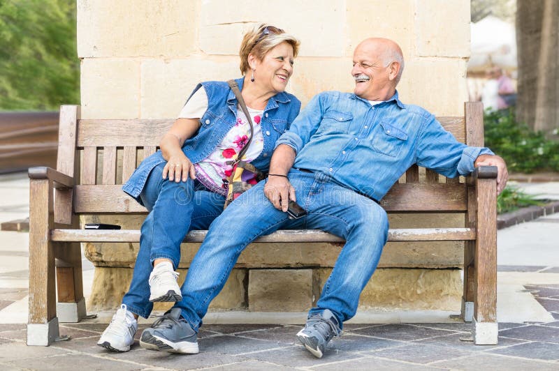 Glückliche ältere Paare, die Spaß auf einer Bank - Konzept aktiven pl haben