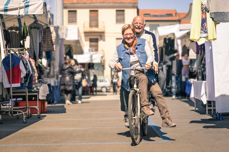 Glückliche ältere Paare, die Spaß mit Fahrrad an der Flohmarkt haben