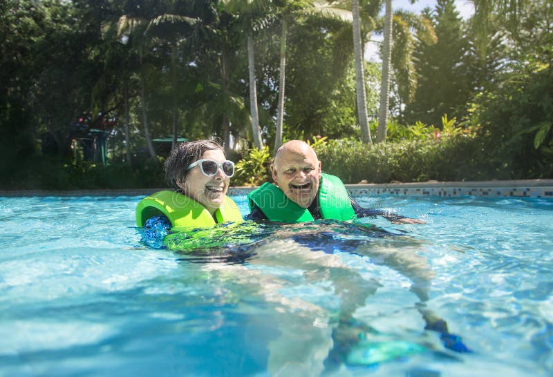 Glückliche ältere Paare, die zusammen auf einem faulen Fluss schwimmen stockbilder Glückliche ältere Paare, die zusammen auf einem faulen Fluss schwimmen stockbilder