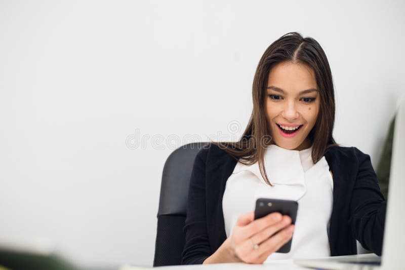 Glückliche überraschende Frau, die im Handy schaut und Mitteilung mit offenem Mund liest