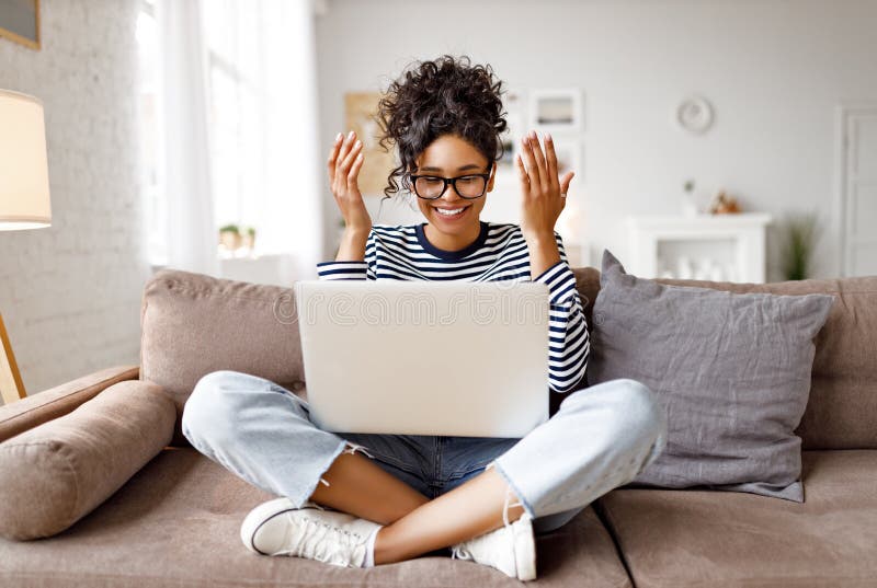 Glückliche überraschte ethnische Frau, die Videokonferenz auf Notebook macht lizenzfreie stockfotografie