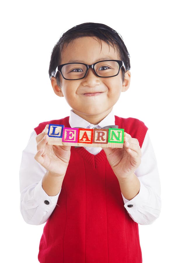 Asian elementary school student showing letter blocks spelling out LEARN. shot in studio isolated on white. Asian elementary school student showing letter blocks spelling out LEARN. shot in studio isolated on white