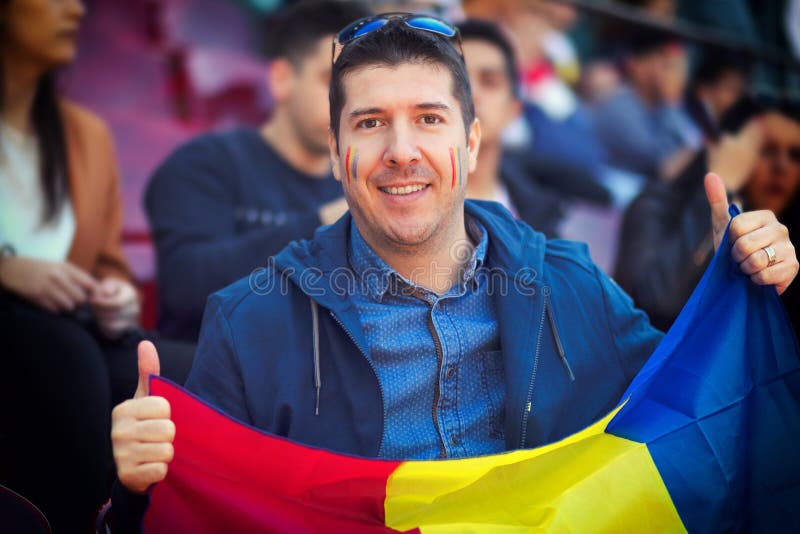 Glücklicher Anhänger, der rumänische Staatsflagge in den Händen an internationalem Sportereignis †„Mann in den Ständen des Stad lizenzfreie stockfotografie Glücklicher Anhänger, der rumänische Staatsflagge in den Händen an internationalem Sportereignis †„Mann in den Ständen des Stad lizenzfreie stockfotografie