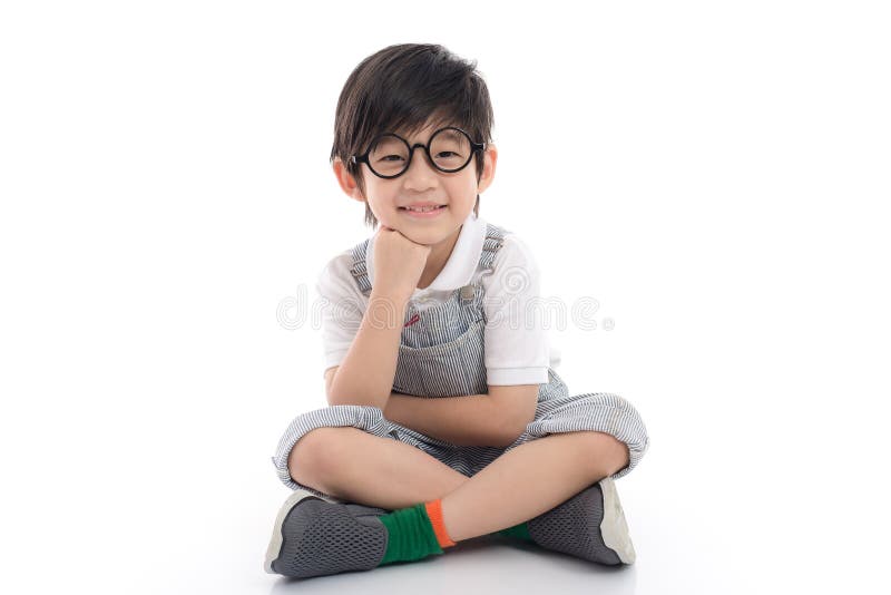 Glücklicher asiatischer Junge, der auf weißem Hintergrund sitzt lizenzfreies stockfoto Glücklicher asiatischer Junge, der auf weißem Hintergrund sitzt lizenzfreies stockfoto