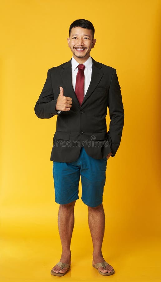 Happy asian man in flip flops with thumb up isolated on yellow background. Happy asian man in flip flops with thumb up isolated on yellow background