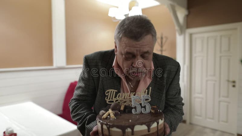 Glücklicher beachtlicher Holdingkuchen des alten Mannes feiern Schlaggeburtstagskerzen