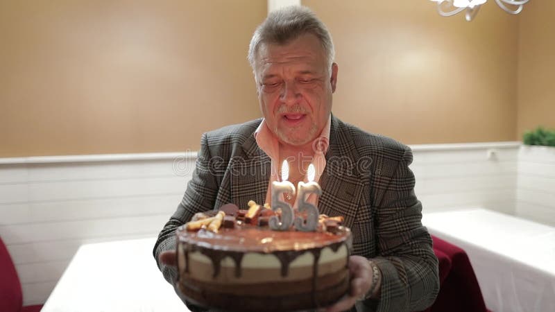 Glücklicher beachtlicher Holdingkuchen des alten Mannes feiern Schlaggeburtstagskerzen