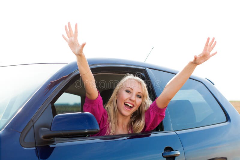 Glücklicher blonder Mädchenfahrer im Autofenster