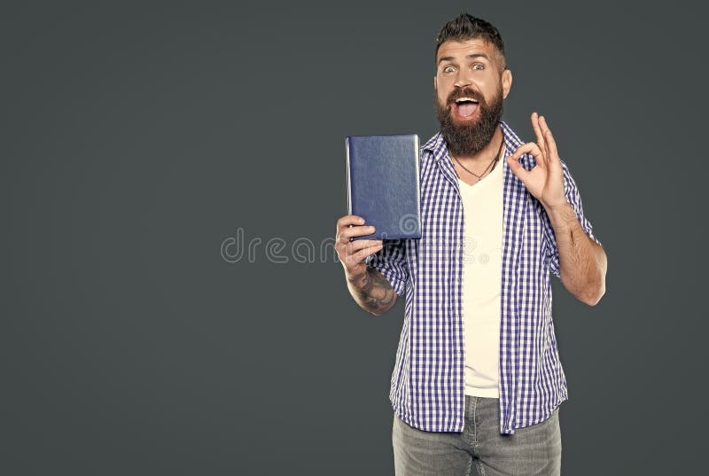 Glücklicher Bärenmann empfiehlt Buch auf grauem Hintergrund. kochen lizenzfreies stockfoto