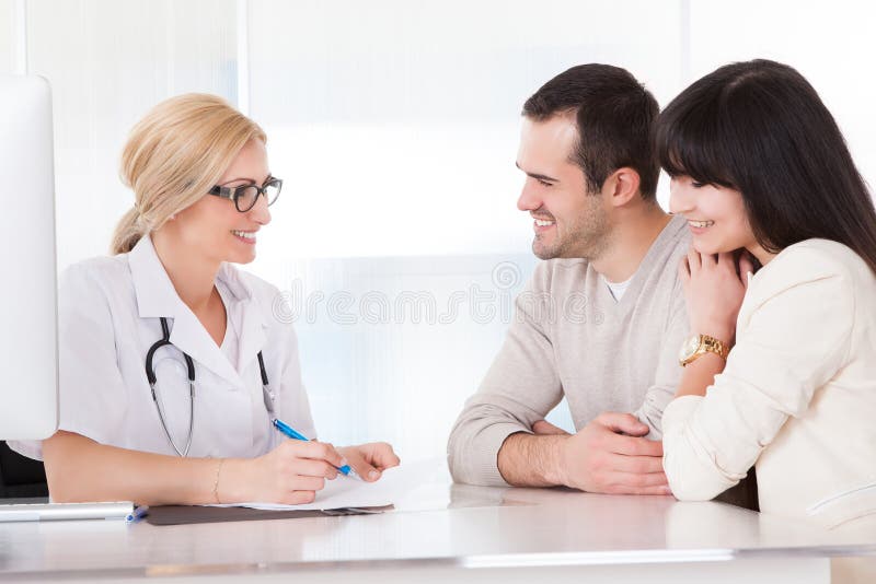 Glücklicher Doktor Discussing With Couple lizenzfreie stockfotos Glücklicher Doktor Discussing With Couple lizenzfreie stockfotos