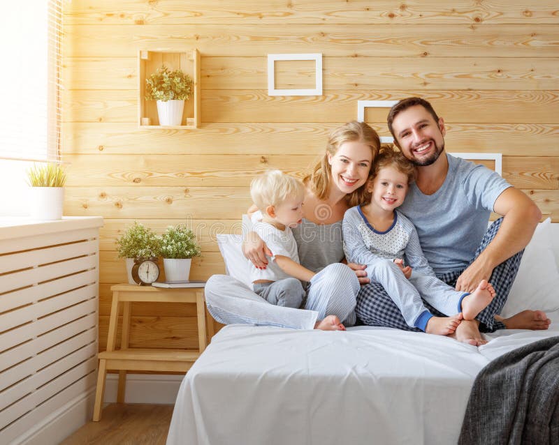 Glücklicher Familienmuttervater und Kinder Tochter und Sohn im Bett stockfoto Glücklicher Familienmuttervater und Kinder Tochter und Sohn im Bett stockfoto
