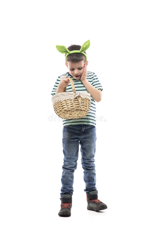 Glücklicher faszinierter junger stolzer Junge, der voll und ganz Korb von Eiern nach Auffassung Ostern-Jagd. lizenzfreies stockfoto