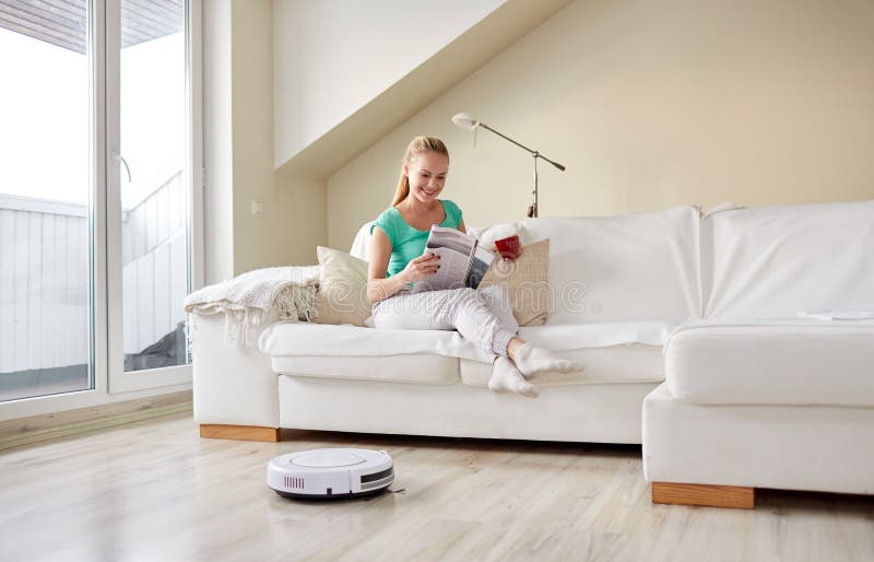Glücklicher Frauen- und RoboterStaubsauger zu Hause lizenzfreies stockbild Glücklicher Frauen- und RoboterStaubsauger zu Hause lizenzfreies stockbild