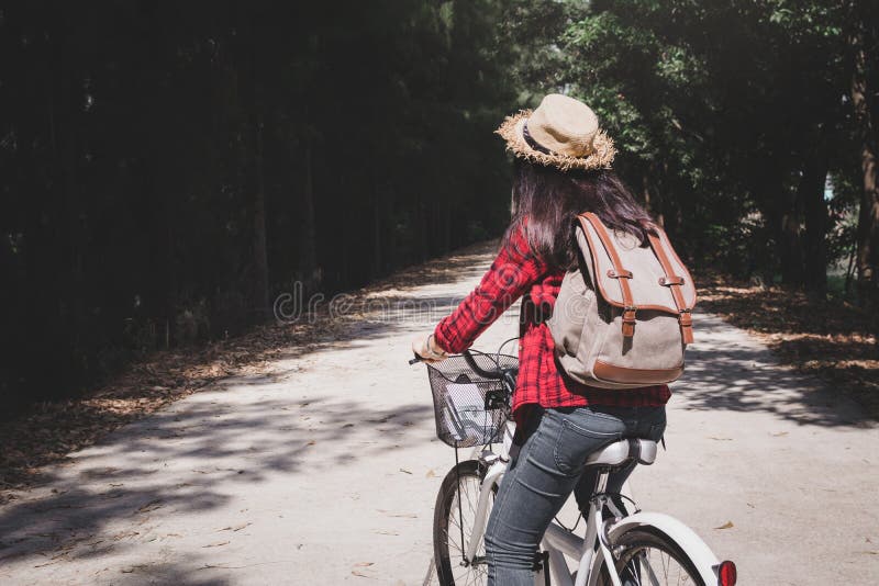 Glücklicher Frauenwanderer mit weißem Fahrrad in der Natur