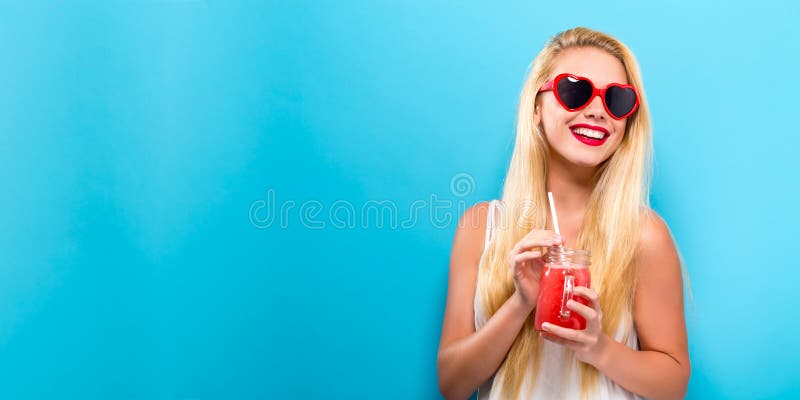 Glücklicher junge Frau trinkender Smoothie