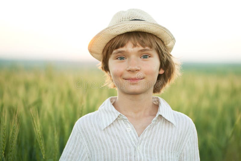 Happy boy in the hat among the wheat field on a summer evening. Happy boy in the hat among the wheat field on a summer evening