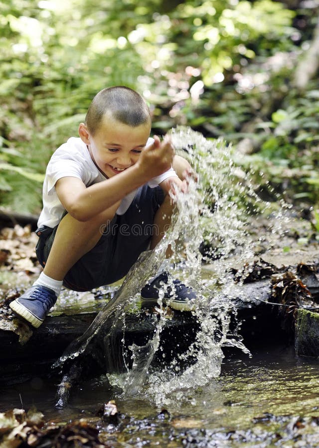 Glücklicher Junge spielt mit Wasser stockfotografie Glücklicher Junge spielt mit Wasser stockfotografie