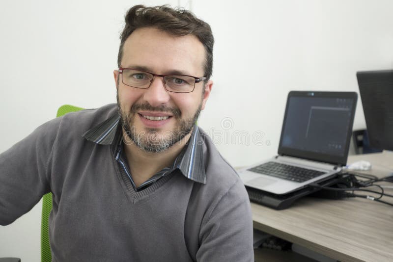 Glücklicher junger Geschäftsmann, Softwareentwickler, Computertechniker, der im modernen Büro arbeitet stockbilder Glücklicher junger Geschäftsmann, Softwareentwickler, Computertechniker, der im modernen Büro arbeitet stockbilder