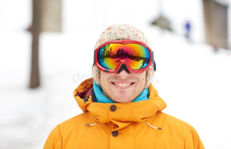 Glücklicher junger Mann in den Skischutzbrillen draußen