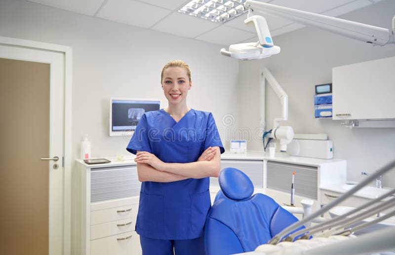 Glücklicher junger weiblicher Zahnarzt im zahnmedizinischen Klinikbüro stockbild Glücklicher junger weiblicher Zahnarzt im zahnmedizinischen Klinikbüro stockbild