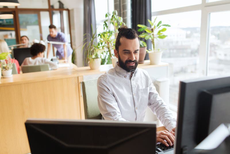Glücklicher kreativer männlicher Büroangestellter mit Computer stockbilder Glücklicher kreativer männlicher Büroangestellter mit Computer stockbilder