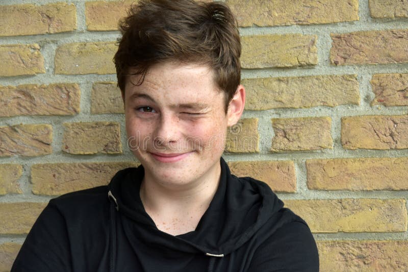 Portrait of a happy smiling teenage boy with many freckles . He tries to wink in vain. Portrait of a happy smiling teenage boy with many freckles . He tries to wink in vain