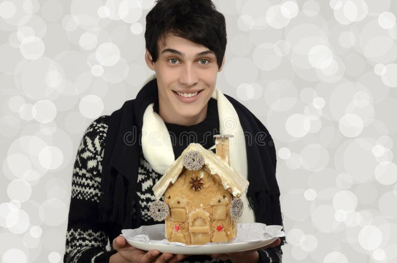 Glücklicher Mann, der ein Lebkuchenhaus hält stockfoto Glücklicher Mann, der ein Lebkuchenhaus hält stockfoto