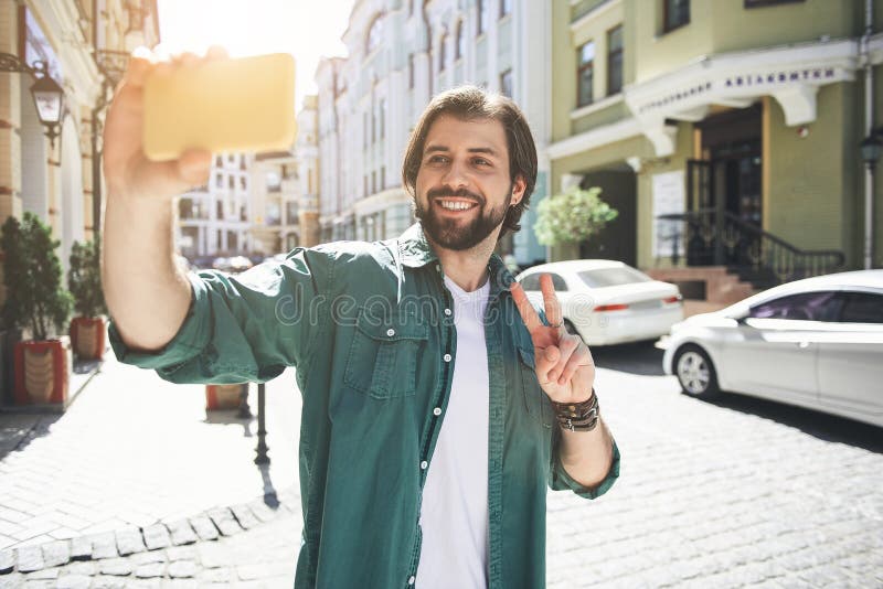 Glücklicher Mann, der selfie im Marktplatz macht stockfotografie Glücklicher Mann, der selfie im Marktplatz macht stockfotografie