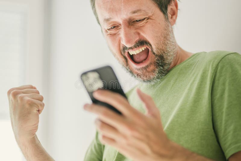 Happy man received satisfying text message on mobile smartphone, selective focus. Happy man received satisfying text message on mobile smartphone, selective focus