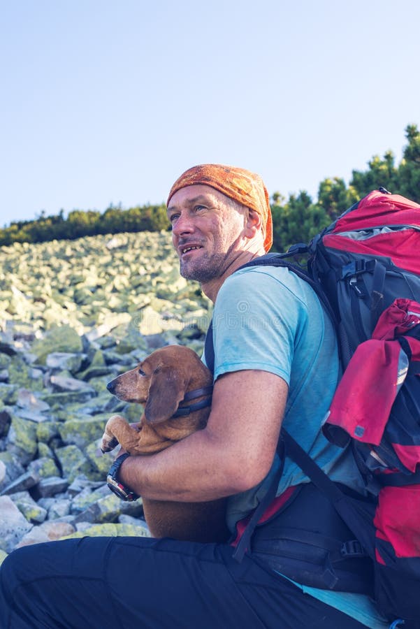 Glücklicher Mannreisender mit einem lustigen Hund lizenzfreie stockbilder Glücklicher Mannreisender mit einem lustigen Hund lizenzfreie stockbilder
