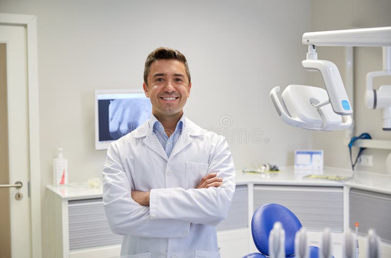 Glücklicher männlicher Zahnarzt im zahnmedizinischen Klinikbüro stockbild Glücklicher männlicher Zahnarzt im zahnmedizinischen Klinikbüro stockbild