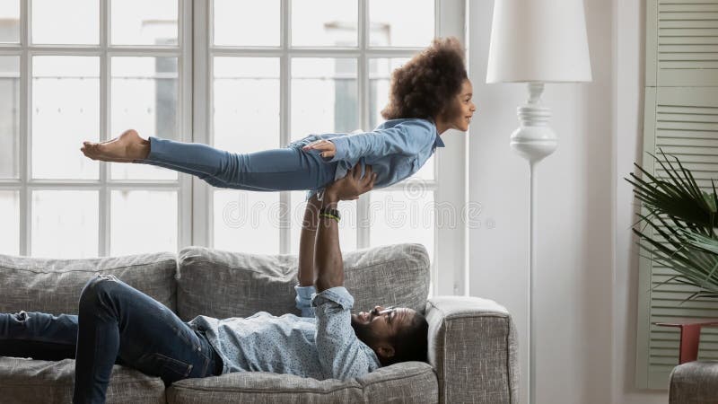 Glücklicher starker Vater und kleine Tochter, die komische Tätigkeiten genießt stockfoto