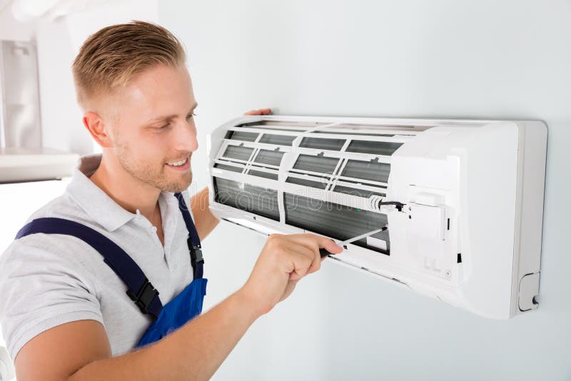 Glücklicher Techniker Repairing Air Conditioner lizenzfreies stockbild Glücklicher Techniker Repairing Air Conditioner lizenzfreies stockbild