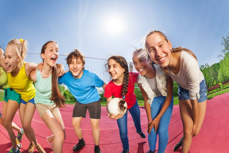 Glücklicher Teenager, der auf dem Volleyballspielgericht steht lizenzfreie stockbilder Glücklicher Teenager, der auf dem Volleyballspielgericht steht lizenzfreie stockbilder