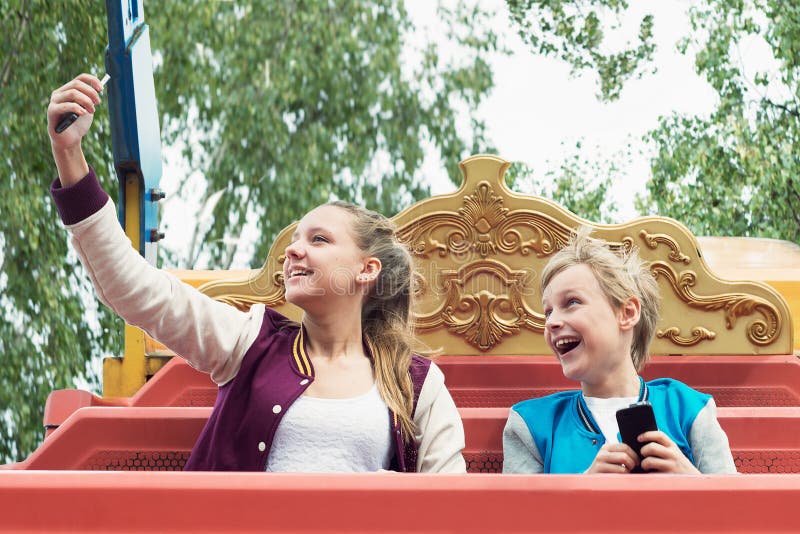 Glücklicher Teenager fährt auf das Karussell und macht selfie stockbild Glücklicher Teenager fährt auf das Karussell und macht selfie stockbild