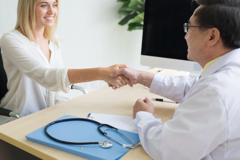 Glücklicher und lächelnder Frauenpatient, der Händedruck gibt, um Doktor am Krankenhaus zu bemannen stockfotos Glücklicher und lächelnder Frauenpatient, der Händedruck gibt, um Doktor am Krankenhaus zu bemannen stockfotos