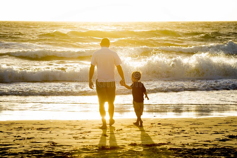 Glücklicher Vater, der die Hand des kleinen Sohns zusammen gehend auf den Strand mit barfuß hält stockfoto Glücklicher Vater, der die Hand des kleinen Sohns zusammen gehend auf den Strand mit barfuß hält stockfoto