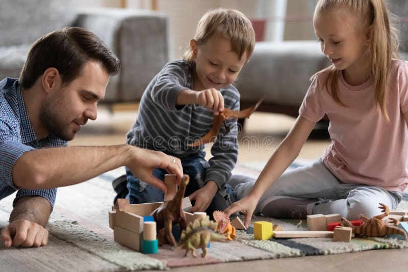 Glücklicher Vater, der zu Hause mit weniger Tochter und Sohn, es läuft. stockfotografie