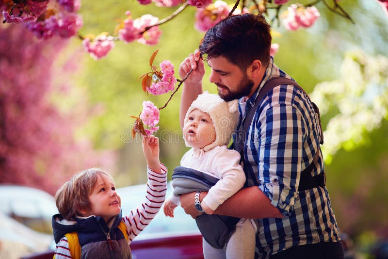 Glücklicher Vater mit Kindern auf der Stadt des Wegs im Frühjahr, Babytrage, väterlicher Urlaub lizenzfreies stockfoto Glücklicher Vater mit Kindern auf der Stadt des Wegs im Frühjahr, Babytrage, väterlicher Urlaub lizenzfreies stockfoto