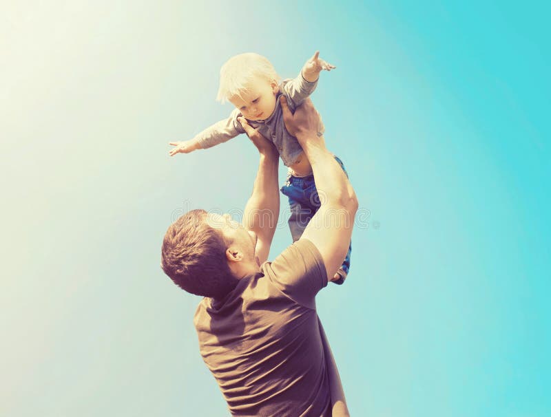 Glücklicher Vater und Sohn, die zusammen Spaß draußen über Himmel habend spielt lizenzfreie stockfotos Glücklicher Vater und Sohn, die zusammen Spaß draußen über Himmel habend spielt lizenzfreie stockfotos