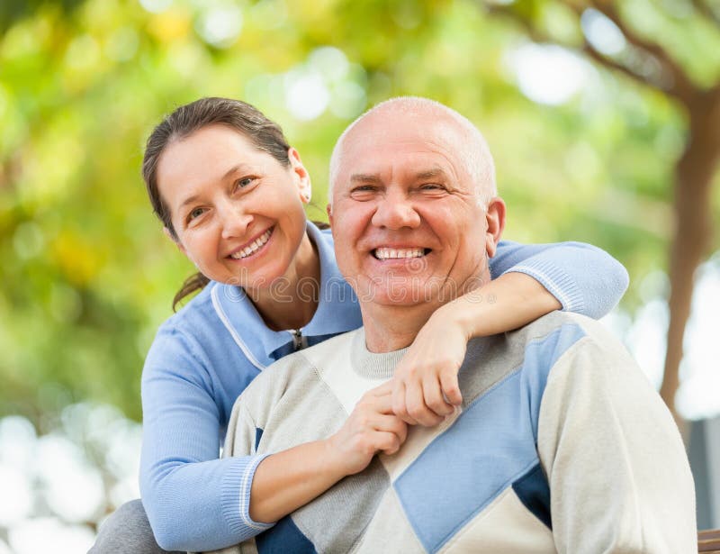 Glücklicher älterer Mann und reife Frau gegen den Park stockfoto Glücklicher älterer Mann und reife Frau gegen den Park stockfoto