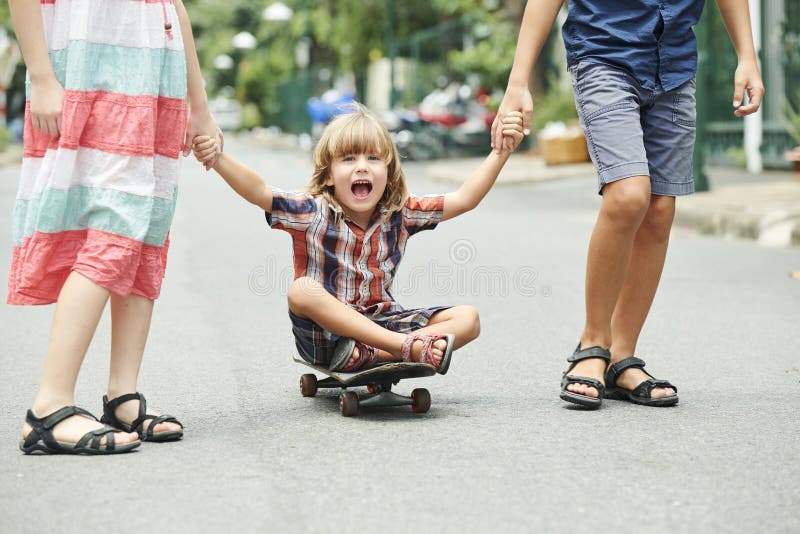 Glückliches aufgeregtes Kind auf Skateboard lizenzfreie stockfotografie Glückliches aufgeregtes Kind auf Skateboard lizenzfreie stockfotografie