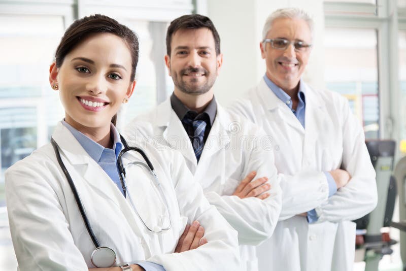 Glückliches erfolgreiches Ärzteteam in einem Krankenhaus stockfotografie Glückliches erfolgreiches Ärzteteam in einem Krankenhaus stockfotografie