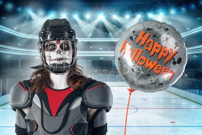 Glückliches Halloween Hockeyspieler in einem Hockeysturzhelm und -maske mit einem Ballon gegen den Hintergrund oder Hintergrund e stockbild Glückliches Halloween Hockeyspieler in einem Hockeysturzhelm und -maske mit einem Ballon gegen den Hintergrund oder Hintergrund e stockbild