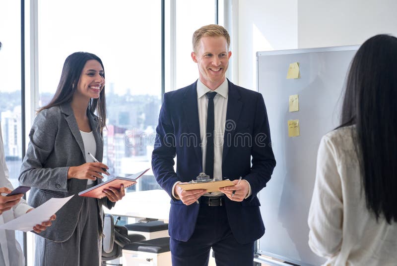 Glückliches internationales Geschäftsteam, das bei der Sitzung mit Whiteboard zusammenarbeitet. stockfoto