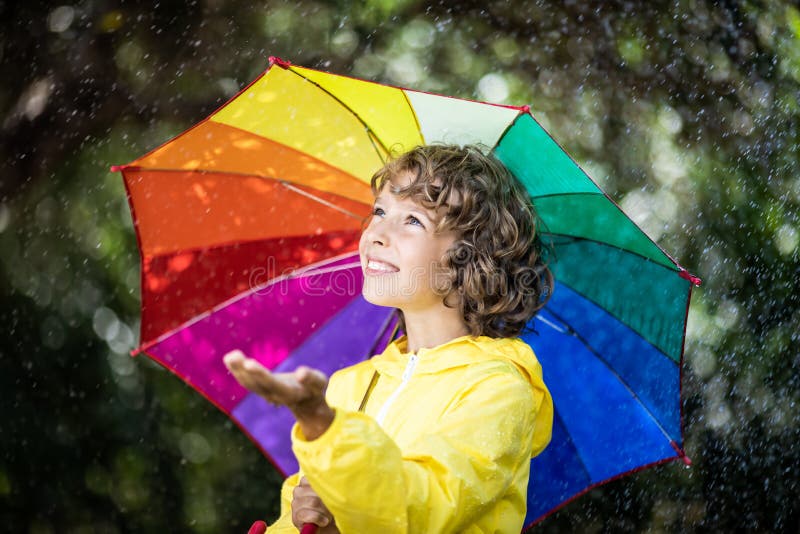 Glückliches Kind, das im Regen spielt stockfotos Glückliches Kind, das im Regen spielt stockfotos