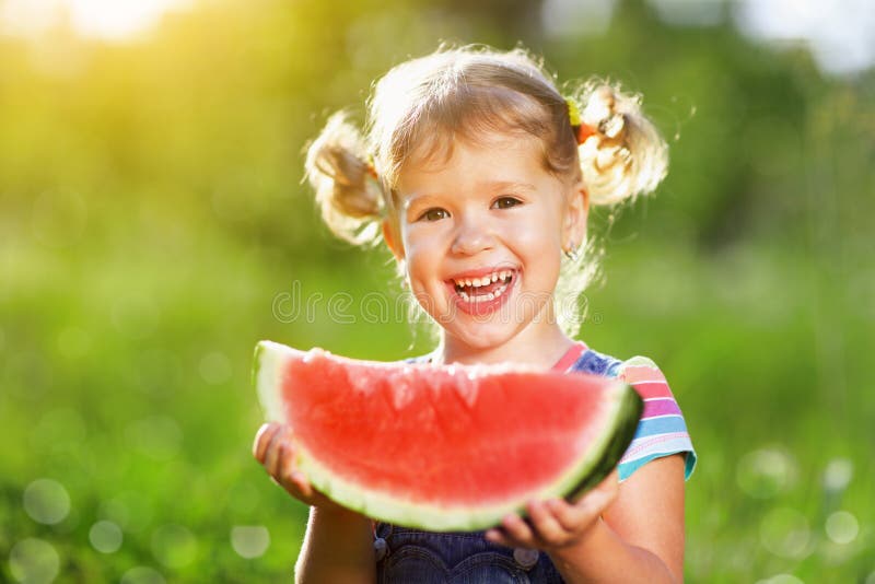 Glückliches Kindermädchen isst Wassermelone stockfotografie Glückliches Kindermädchen isst Wassermelone stockfotografie